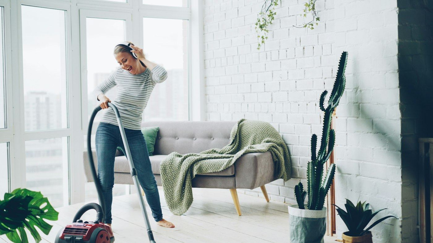 Cleaner vacuuming a bright living room