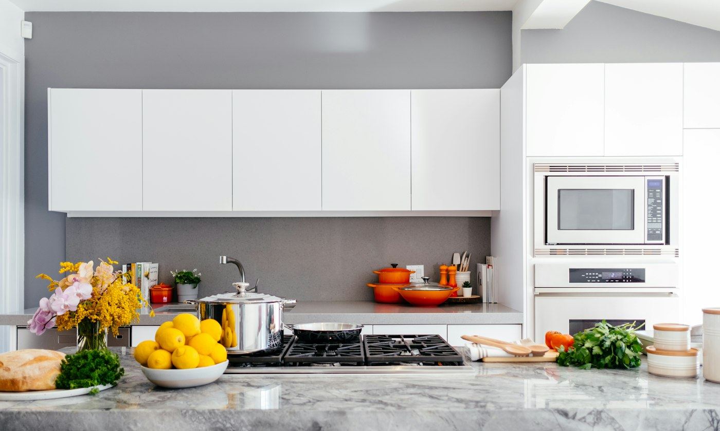 Clean white kitchen with marble counters